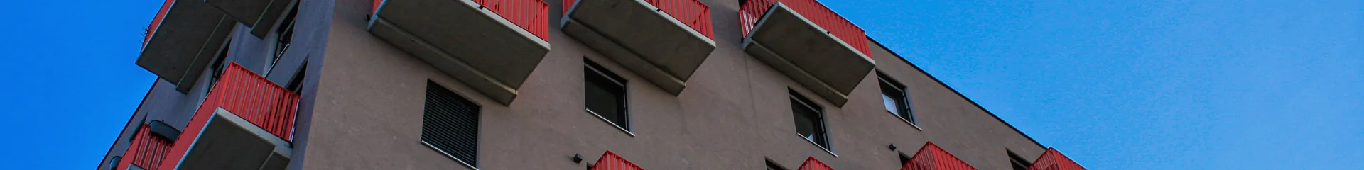 Modernes Wiener Wohngebäude mit roten Balkonen